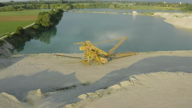 A Bucket Wheel Excavator sitting quietly by a lake in Bruckmuehl, Germany - aerial