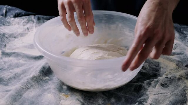 Man stretching and folding a  sourdough in the kitchen