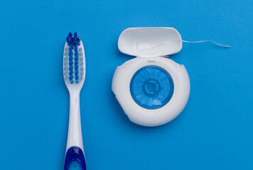 Close up of toothbrush and dental floss on blue background