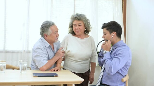 Asian elder couple are meeting doctor at home.