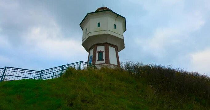 A Lighthouse And Water Tower At The Island Of Langeoog, Lower Saxony, Germany At Daytime. - Low Angle Shot - timelapse