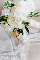 Elegant wedding accessories of an attractive bride. Wedding rings, shoes, bridal bouquet, floral arrangements, veil. Copy space for text. Background for greeting card or invitation.