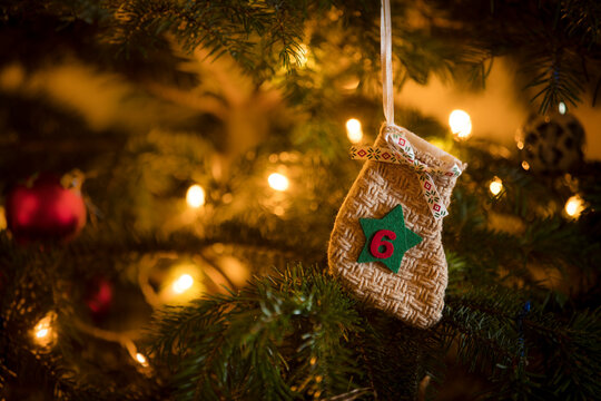 Traditional Advent Calendar Stocking with the date of the sixth of December hanging on a traditional christmas tree.