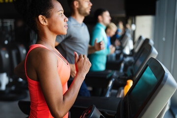 Fototapeta na wymiar People running on treadmill in gym doing cardio workout