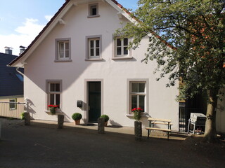 Schönes saniertes altes Haus mit heller Fassade und roten Blumen in der Altstadt von Oerlinghausen...