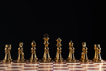 Golden chess figures standing on chessboard