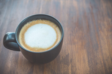 Cup of coffee on brown wooden table at coffee shop. Hot espresso the best start to any morning at cafe with copy space.