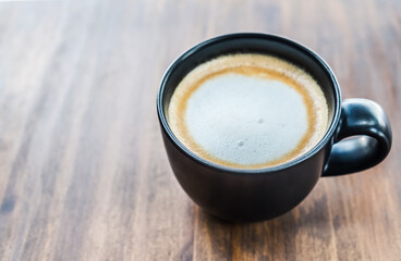 Cup of coffee on brown wooden table at coffee shop. Hot espresso the best start to any morning at cafe with copy space.