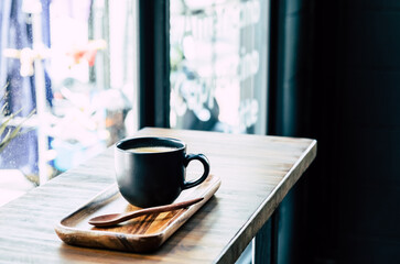 Cup of coffee on brown wooden table at coffee shop. Hot latte the best start to any morning at cafe with copy space.