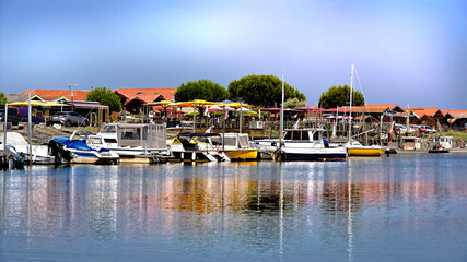 Fototapeta na wymiar Panoramic photo of boats at high tide in the ostreicole harbor of Larros of the commune Gujan-Mestra located on the shore of Arcachon Bay, in the Gironde department in southwestern France.