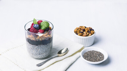 Chia pudding dessert with raspberry jam and granola, mint, blueberry, raspberry on the top
