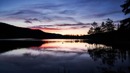 A silhouette of a rower in the beautiful horizon. The sun has set and the sky is very warm and colorful. Shot at a lake outside of Oslo, Norway Called Pershusvatnet. © SteinOve