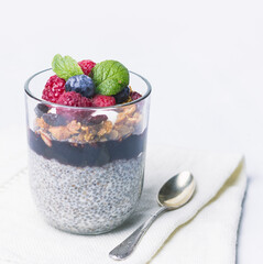 Chia pudding dessert with raspberry jam and granola, mint, blueberry, raspberry on the top
