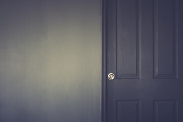 Close up of closed wooden door in the empty room with copy space on the left.