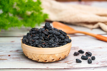 Black raisins  on a wooden table.