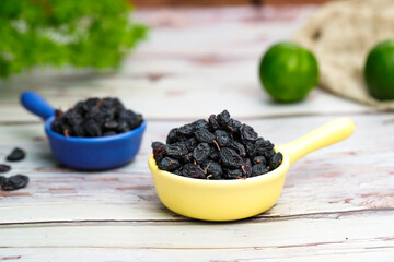 Black raisins  on a wooden table.