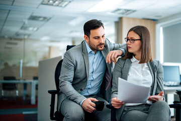Two business people discussing business report, portrait. - obrazy, fototapety, plakaty