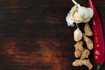Red hot chili peppers and other spices on dark background