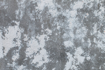 Surface of gray old cement concrete wall with stucco stains. Abstract gray industrial textured background.