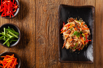 Oriental salad with rice noodles, chicken and mint. Top view.