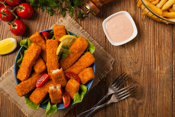 Fish sticks with salad in blue bowl.