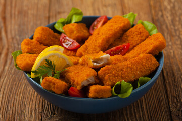 Fish sticks with salad in blue bowl.