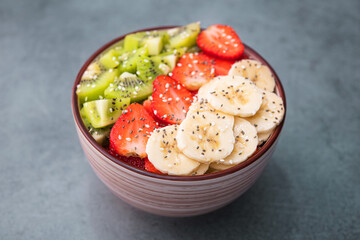 Fresh tasty fruit salad with chia and sesame seeds in bowl
