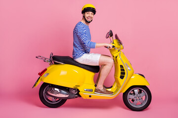 Fototapeta na wymiar Profile side view of his he nice attractive handsome cheerful cheery glad funky guy riding moped exploring world isolated over pink pastel color background