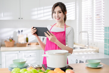 Obraz na płótnie Canvas Asian housewife use tablet