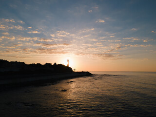 Obraz premium Sunrise with lighthouse and view to the ocean