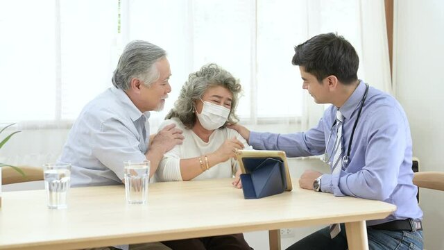 Asian elder couple are meeting doctor at home.