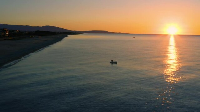 Sagoma di una barca da pesca all'alba nel mare in Calabria