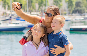 Fototapeta na wymiar happy family taking selfie. Mom and her kids take a picture together