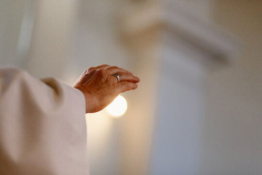 Hand von Prister mit Licht