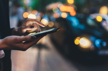 Close up female hand calling taxi with a smartphone app., businesswoman using cellphone with yellow...