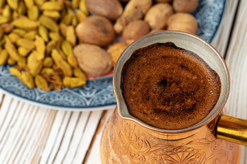 Coffee in metal turk with spices in a plate
