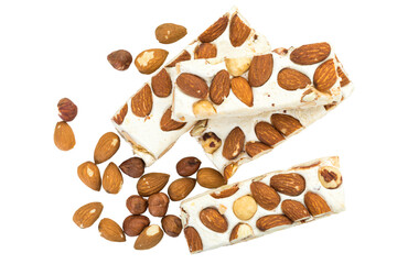 Turron blocks arranged with almonds and hazelnuts, high angle view, isolated on white background