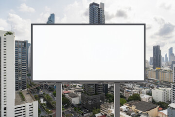 Obraz premium Blank white road billboard with Bangkok cityscape background at day time. Street advertising poster, mock up, 3D rendering. Front view. The concept of marketing communication to promote or sell idea.