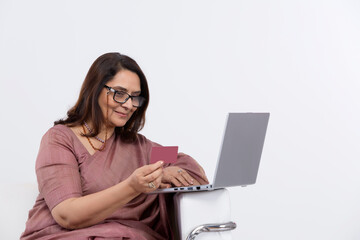 Fototapeta premium Woman doing online shopping using credit card and laptop at home.