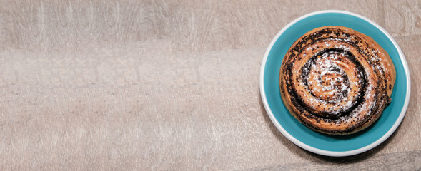 Poppy seed bun on wooden background. Place for text, copy space. Top view
