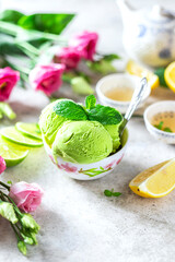 Green tea ice cream with lemon on a gray stone background.