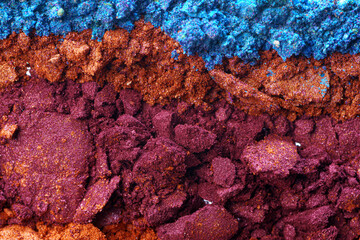 Background of smashed colored eyeshadows pigments close up