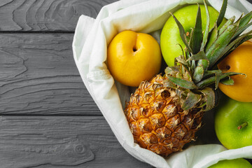 Tropical fruits in white package on black wooden background