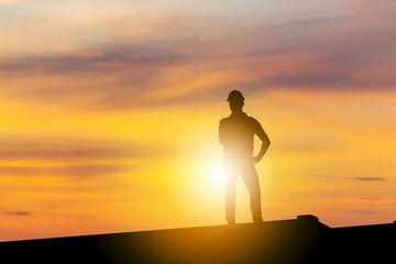 Silhouette of Business engineer man standing on container box evening sunset sky