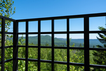 Forged metal fence, observation deck fence, din on a summer mountain landscape. Tourism, travel, outdoors
