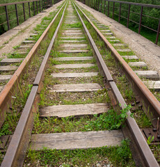 Obraz premium An old Abandoned railway, overgrown with green grass.