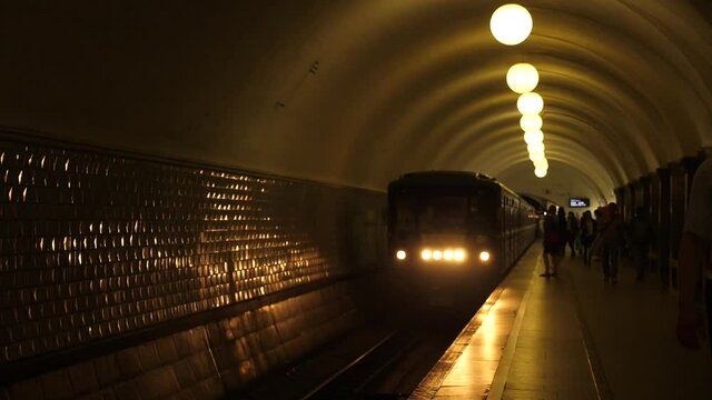 Static shot of a train leaving a station. The shot was taken from the station's platform during daytime. At the beginning of the shot, the train's doors close slowly just before it leaves the station.