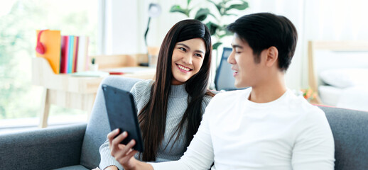 Asian woman smiles sincerely, then puts her boyfriend in the living room, part of his family.