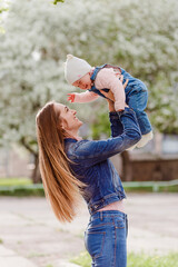 Smiling woman with long hair lifts baby up