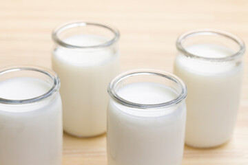 Greek yogurt in a glass jars on wooden background